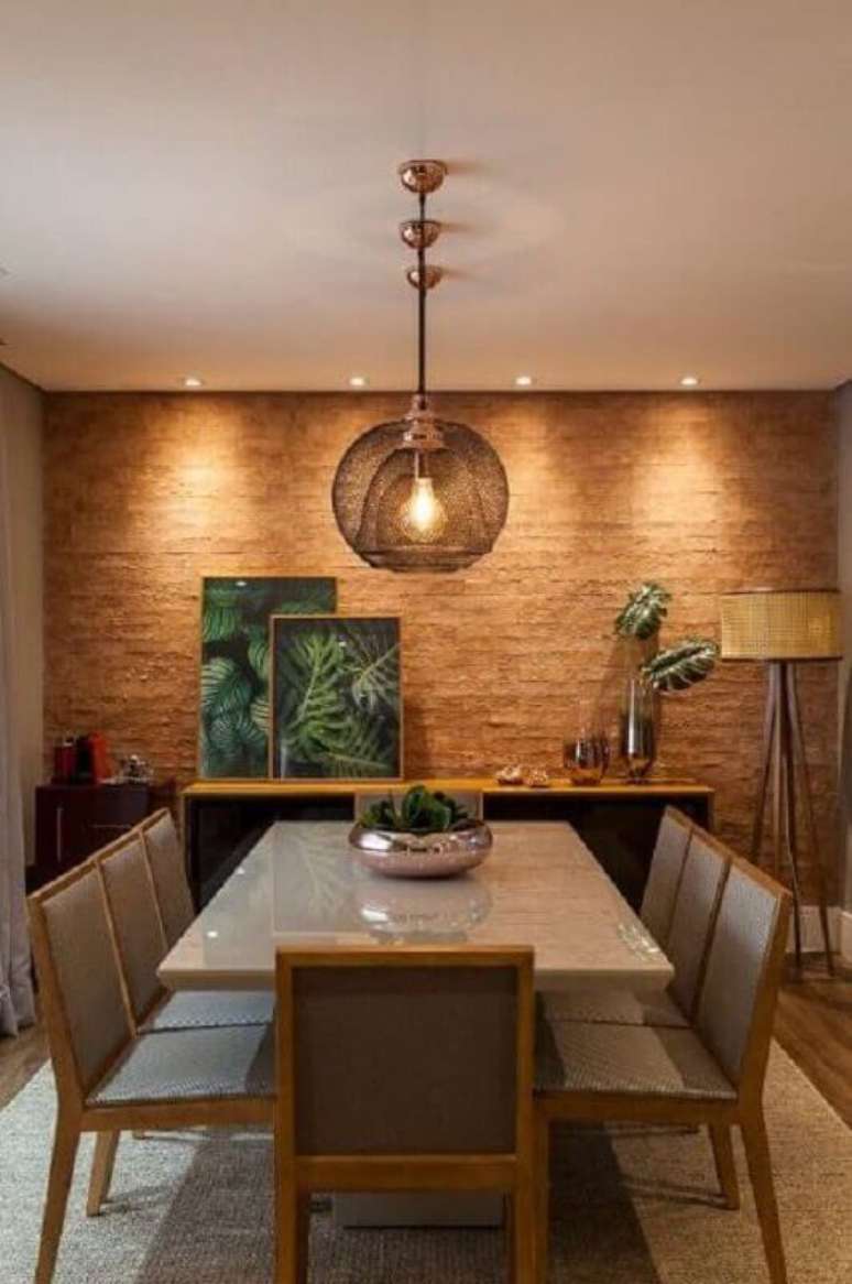 1. Buffet para sala de jantar decorada com abajur de chão e parede rústica – Foto: Jeito de Casa
