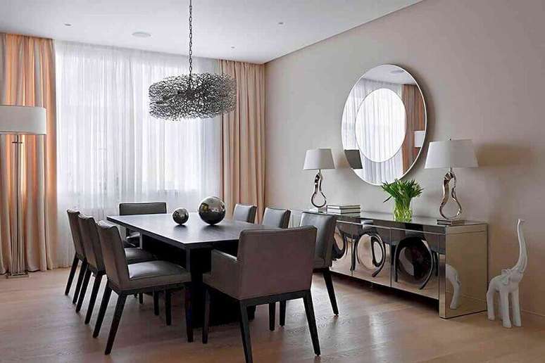 8. Decoração sofisticada para sala de jantar com buffet espelhado e espelho redondo de parede – Foto: Vinh Oanh Glass