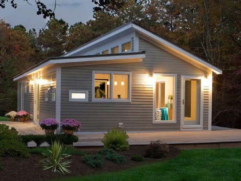 78. Em fachadas de casas simples e com tons neutros, invista em um belo jardim para trazer mais alegria e charme para a entrada da casa. Fonte: Decora&ccedil;&atilde;o e Projetos