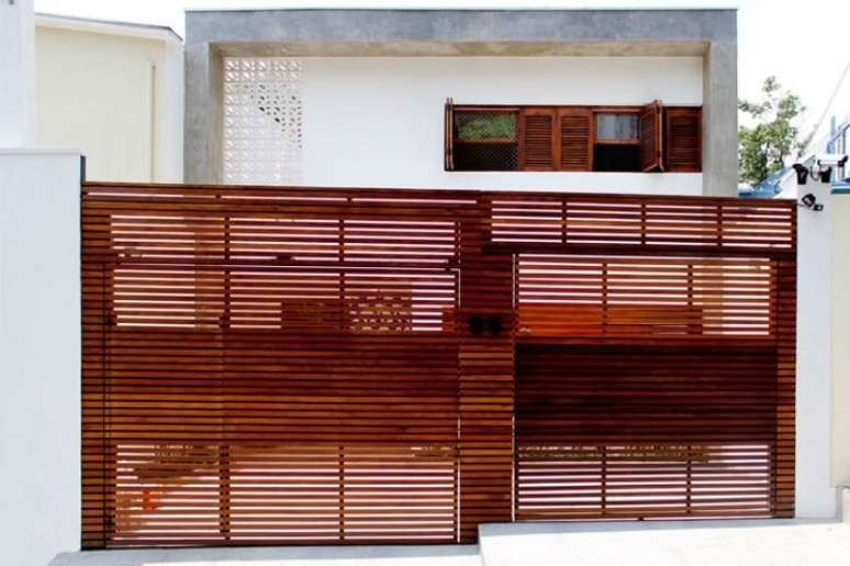 111. Fachada de casas simples com port&atilde;o de madeira. Fonte: Casa 14 Arquitetura