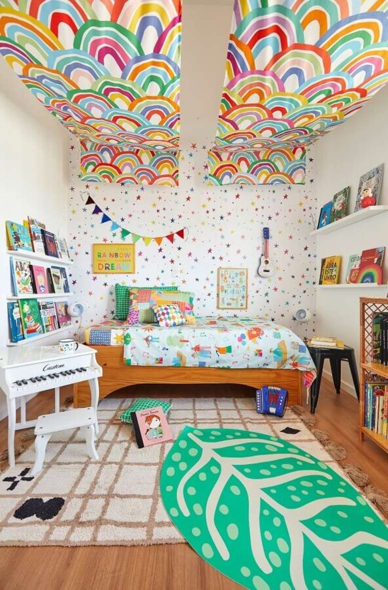 6. Tapete para quarto infantil colorido decorado com prateleiras para livros e cama de madeira – Foto: Marcos Fertonani para MOOUI