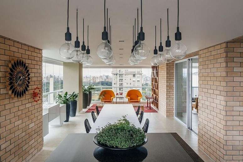7. Parede de tijolinho e lumin&aacute;ria pendente para decora&ccedil;&atilde;o de varanda de apartamento grande &ndash; Foto: FCstudio