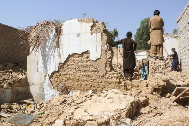 Moradores ao lado de escombros deixados por terremoto em Harnai, no Paquistão
07/10/2021 REUTERS/Naseer Ahmed