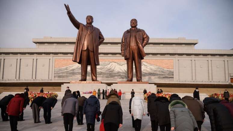 Norte-coreanos se curvam diante das estátuas dos ex-líderes do país, Kim Il-sung e Kim Jong-il