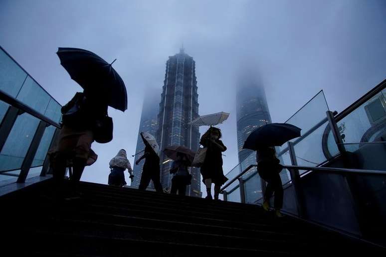 Pedestres seguram guarda-chuvas em Xangai em meio a aproximação do tufão Chanthu
13/09/2021
REUTERS/Aly Song    