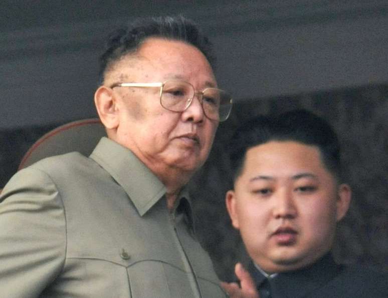 Ex-líder supremo norte-coreano Kim Jong-il com seu filho, Kim Jong-un, ao fundo