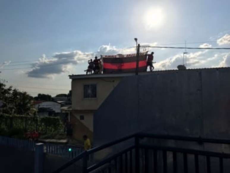 Torcedores subiram no teto de uma casa próxima do estádio para ver o treino (Foto: Sergio Santana/LANCE!)