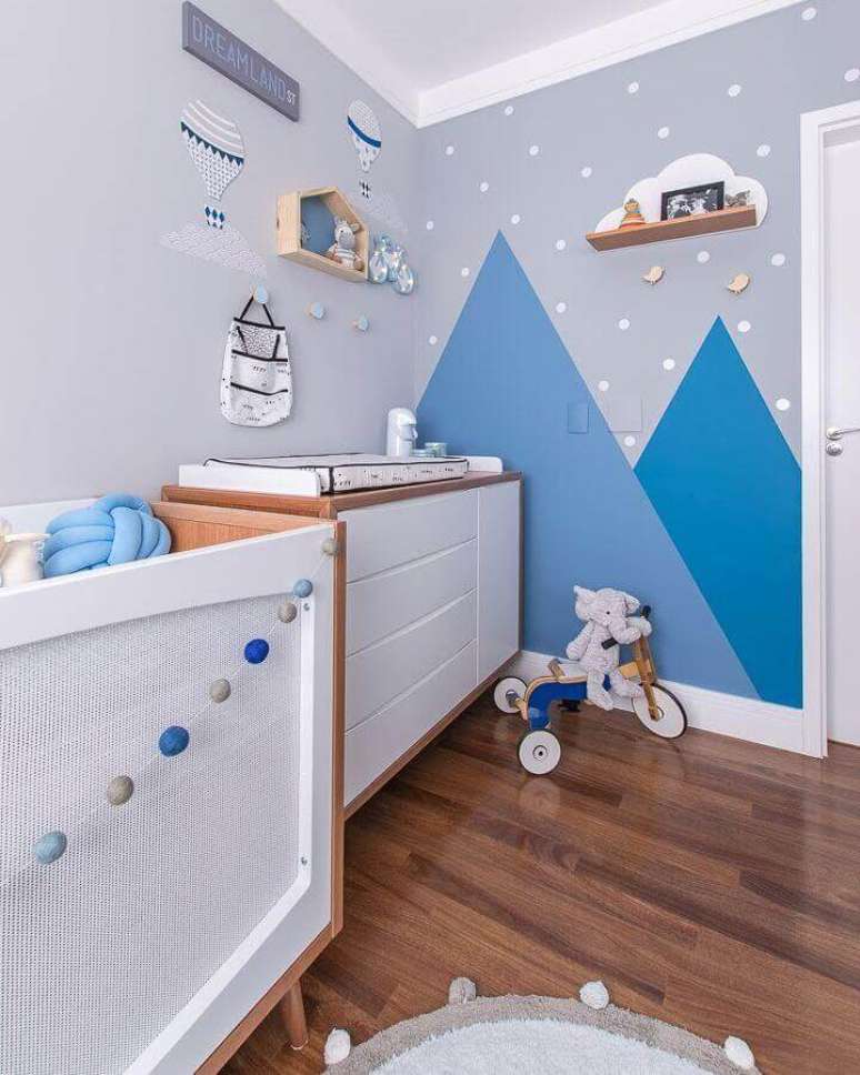 14. Cômoda gaveteiro para quarto de bebê azul e cinza decorado com pintura geométrica na parede – Foto: Juliana Mancini