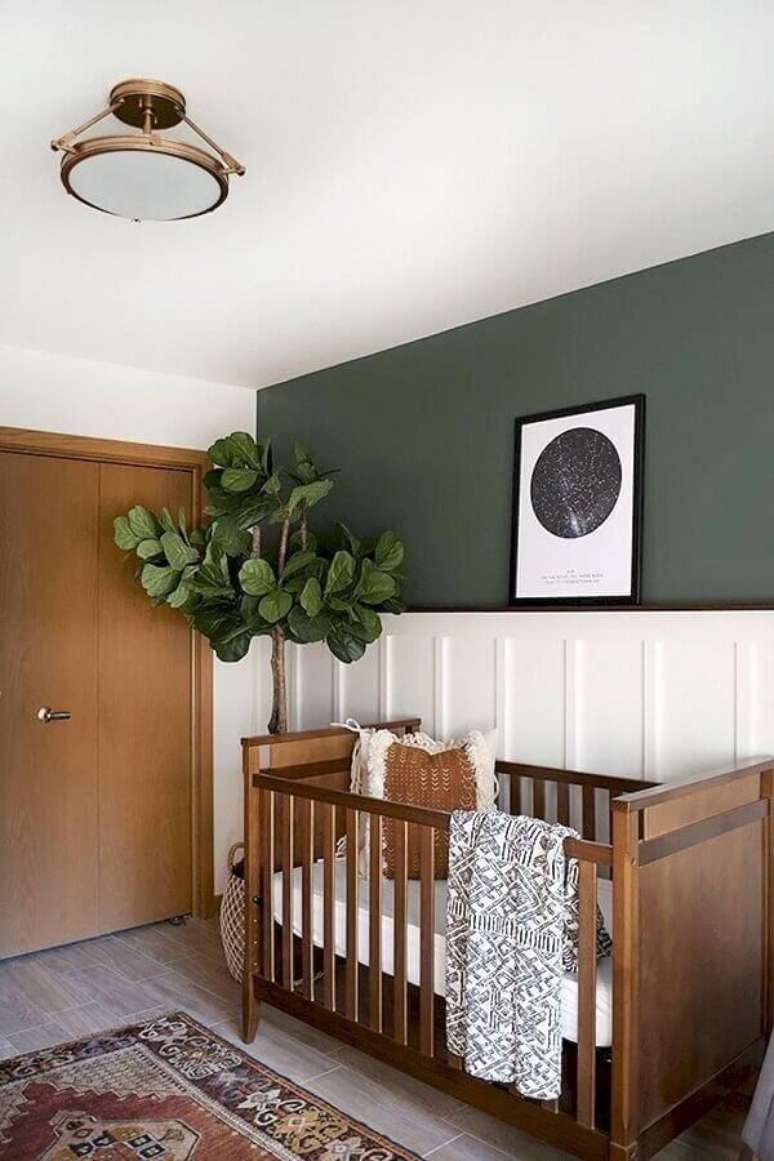 59. Quarto de bebê unissex simples decorado com meia parede pintada e vaso de planta grande – Foto: Omah Home