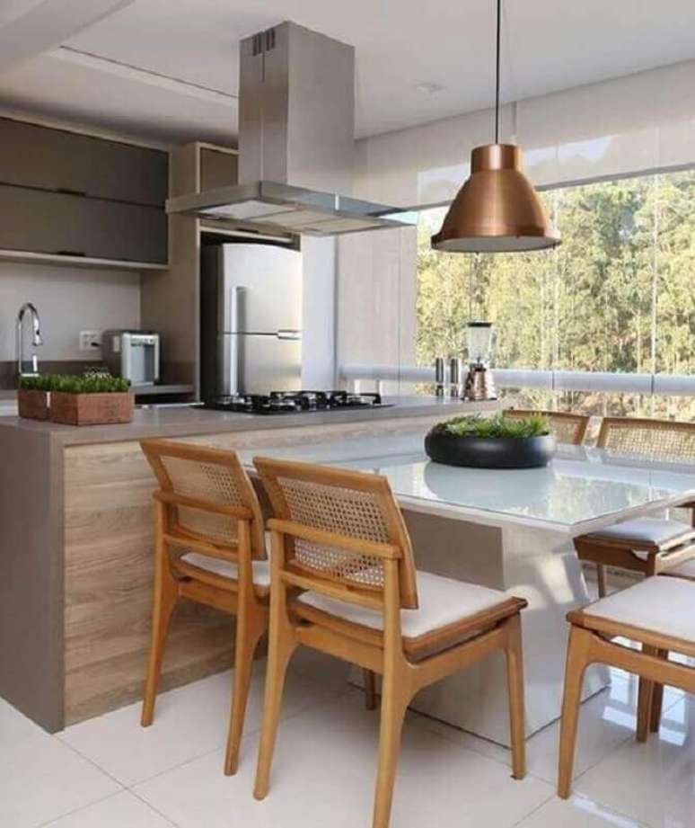 40. Ilha com cooktop e mesa para decoração de cozinha gourmet planejada – Foto: Casa Tres Chic