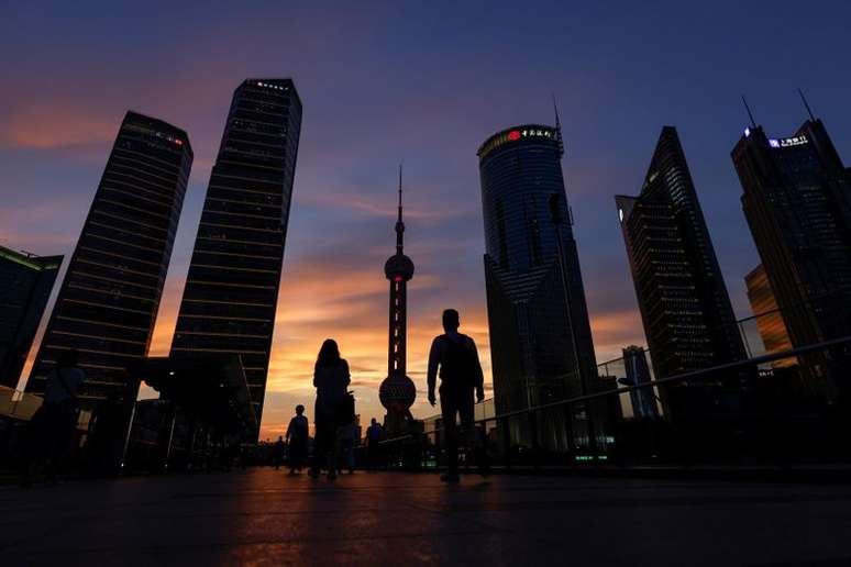 Pessoas caminham no distrito financeiro de Lujiazui durante o pôr do sol em Pudong, Xangai, China, em 13 de julho de 2021. REUTERS/Aly Song