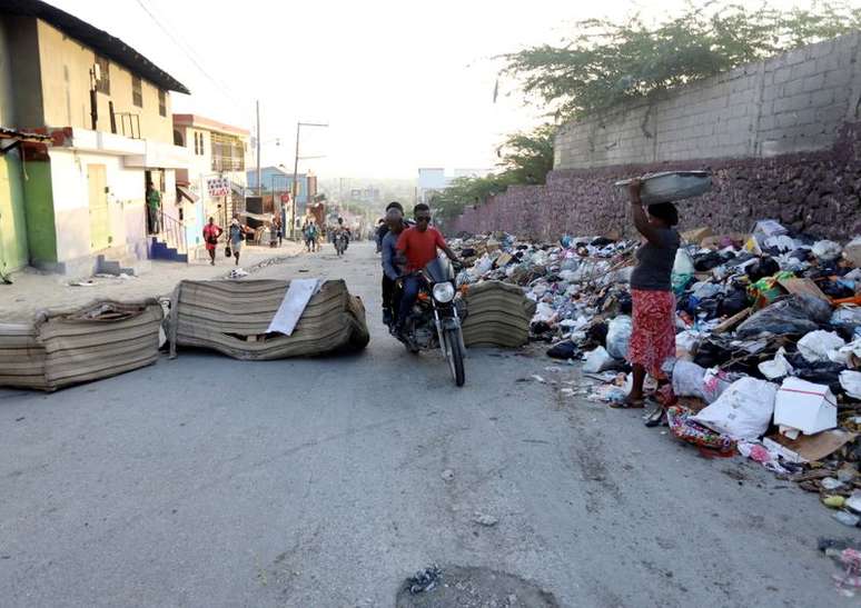 Pessoas passam por barricada em rua de Porto Príncipe, no Haiti
18/10/2021
REUTERS/Ralph Tedy Erol