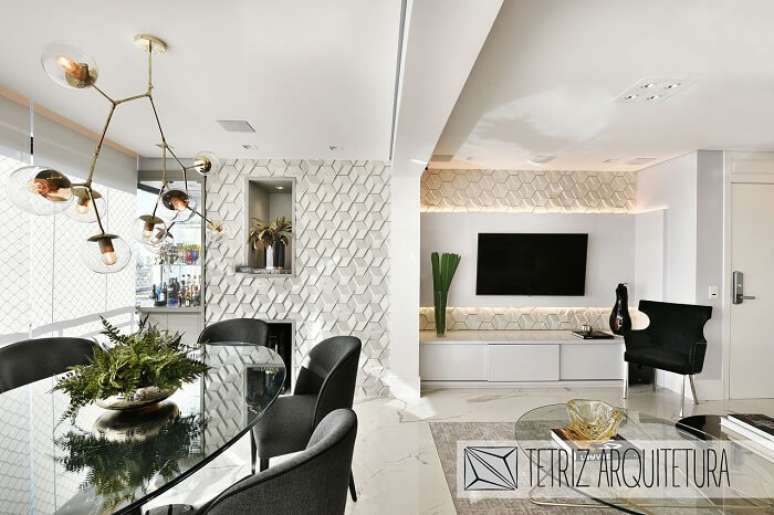 79. Sala de jantar e sala de estar integrada com parede revestida por placa de gesso 3D. Projeto por Tetriz Arquitetura e Interiores