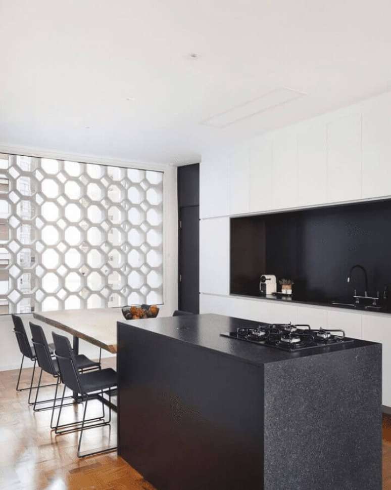 30. Decoração moderna para cozinha preta e branca com ilha com cooktop e mesa – Foto: Mariana Orsi