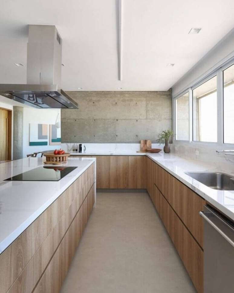 49. Ilha com cooktop para decoração de cozinha com armários de madeira e parede de cimento queimado – Foto: Quattrino Arquitetura
