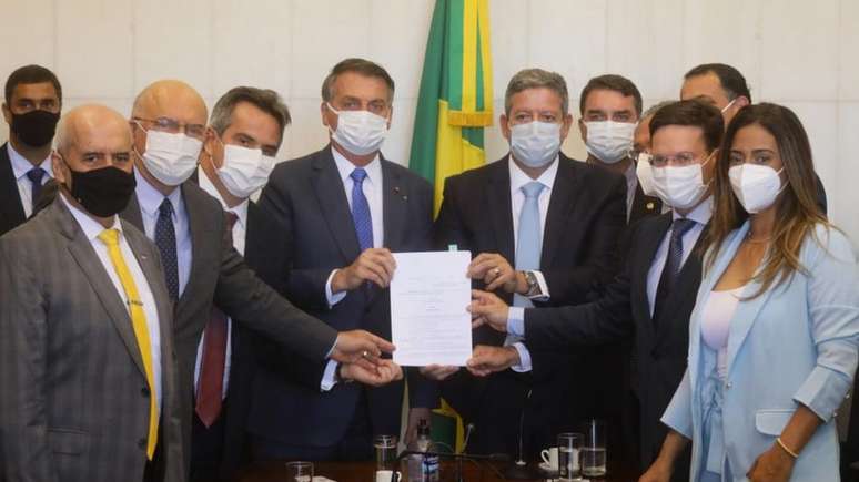 Presidente Jair Bolsonaro rodeado por parlamentares durante entrega da MP do Auxílio Brasil, em agosto; ainda não há clareza sobre a viabilidade do novo benefício