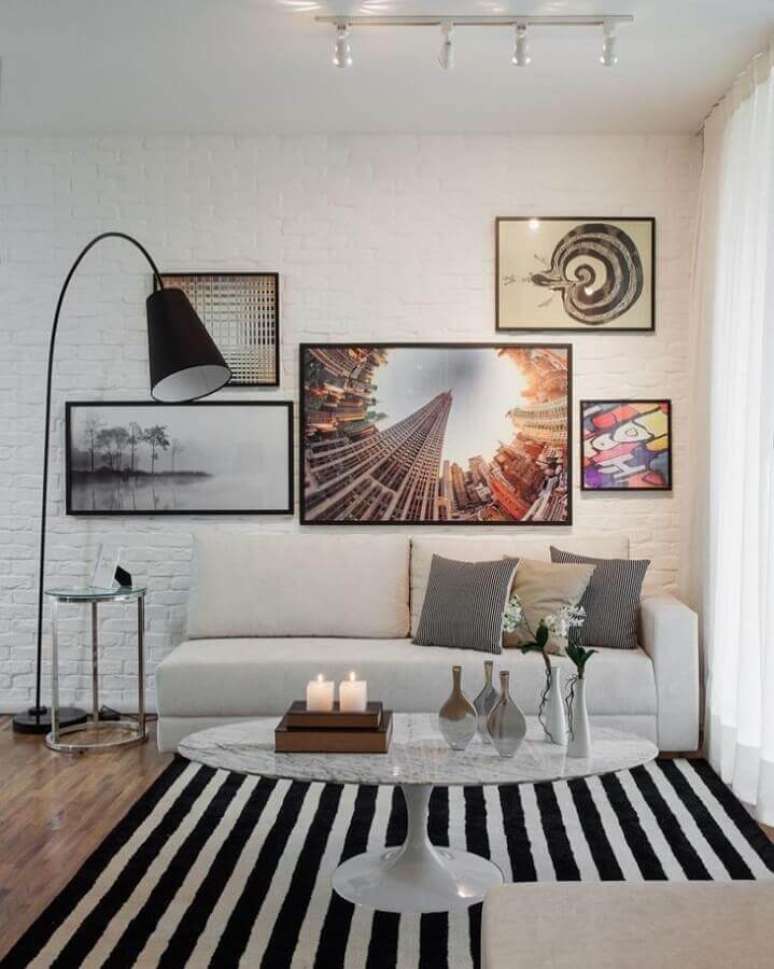 23. Ilumina&ccedil;&atilde;o para sala de estar branca decorada com tapete listrado e parede tijolinho branco &ndash; Foto: Sesso e Dalanezi Arquitetura