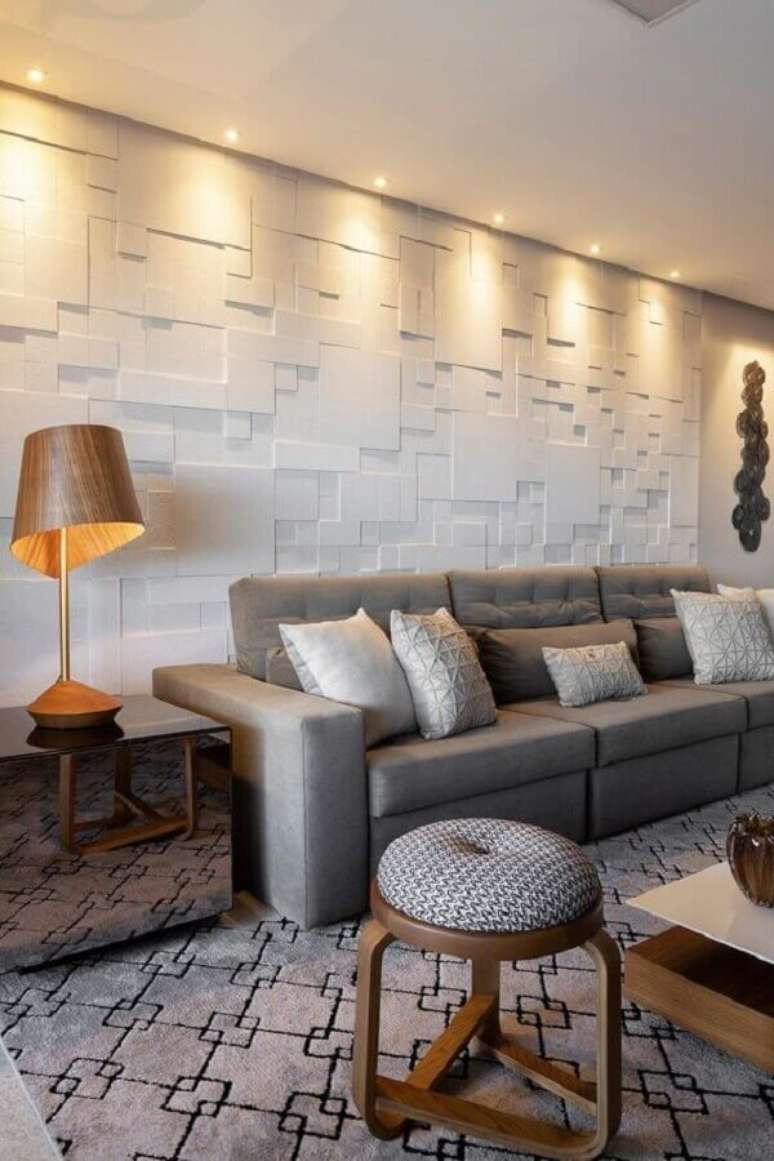 6. Iluminação de sala de estar decorada com abajur de madeira moderno e revestimento 3D – Foto: Castelatto Pisos e Revestimentos