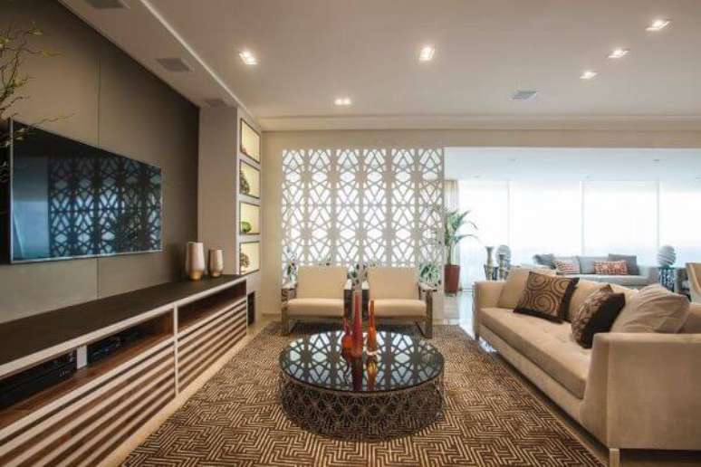 56. Sala de tv com biombo de madeira atrás das poltronas – Foto Caliolo Design