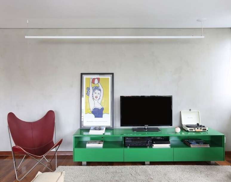 22. Poltrona de couro vermelho e rack para sala moderno verde. Fonte: Lucia Manzano