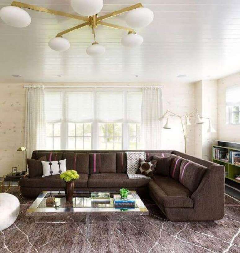 41. Sala com sofá marrom de canto e tapete grande da mesma cor – Foto Decor Facil