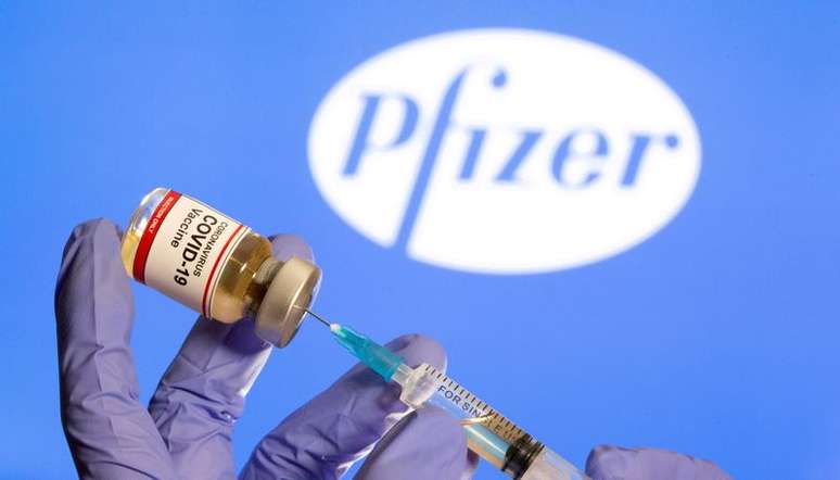 Mulher segura frasco rotulado como de vacina contra Covid-19 em frente ao logo da Pfizer em foto de ilustração
30/10/2020 REUTERS/Dado Ruvic