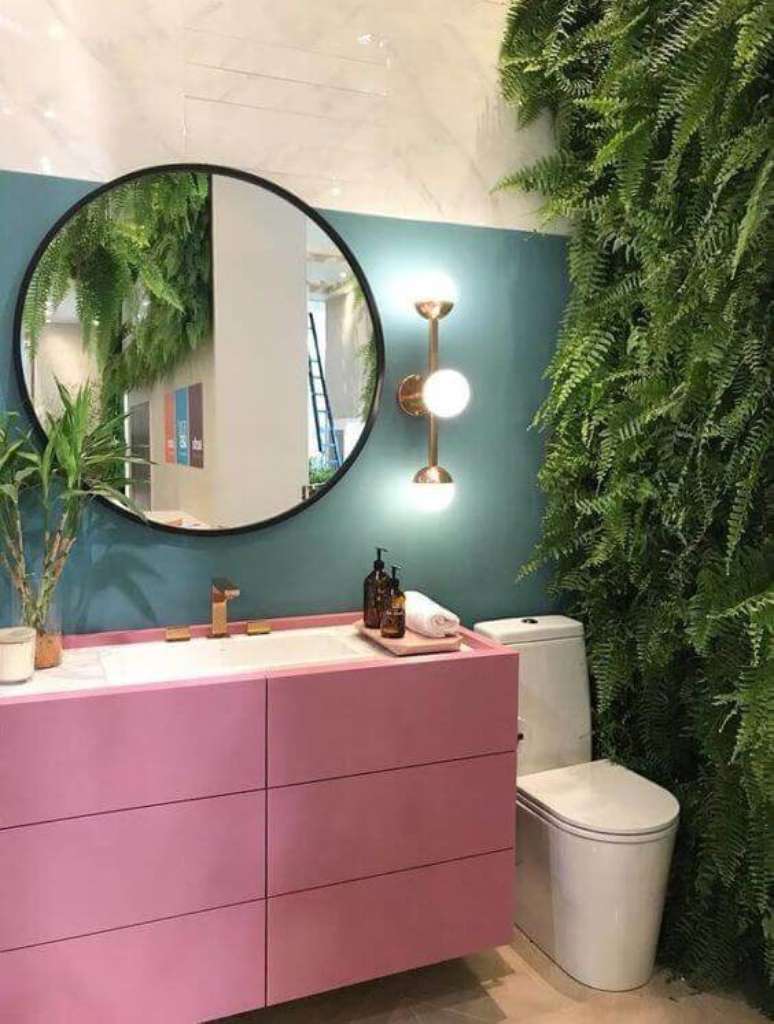 2. Banheiro retro e colorido com moldura redonda preta no espelho e parede de plantas – Foto Na Lata Arquitetura