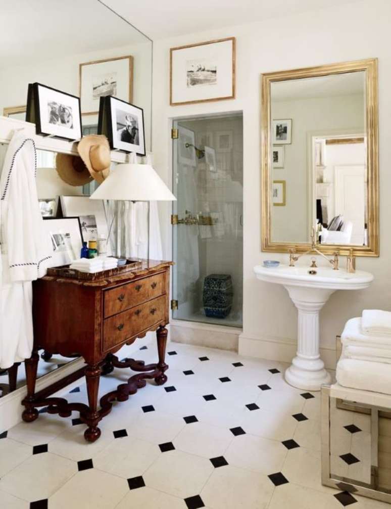 15. Decoração de banheiro retro com cômoda de madeira e espelho dourado – Foto AD