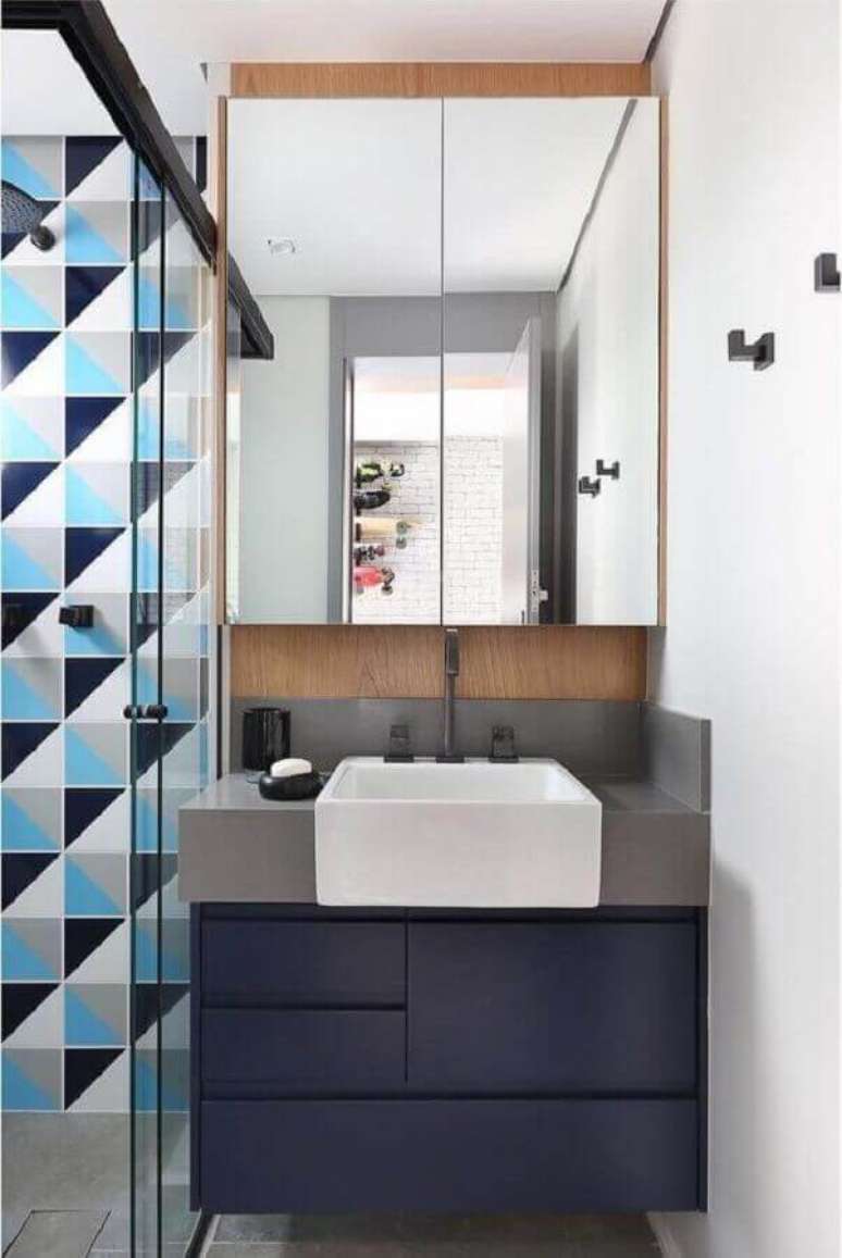 30. Banheiro retrô com revestimento geométrico e gabinete azul marinho – Foto Arkpad