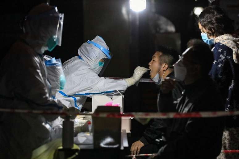 Profissional de sa&uacute;de usando trajes de prote&ccedil;&atilde;o coleta amostra para exame de detec&ccedil;&atilde;o de Covid-19 em Zunyi, na China
21/10/2021 cnsphoto via REUTERS