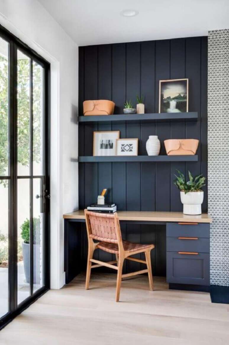 25. Home office pequeno decorado com parede de lambri de madeira preto – Foto: Casa Tres Chic