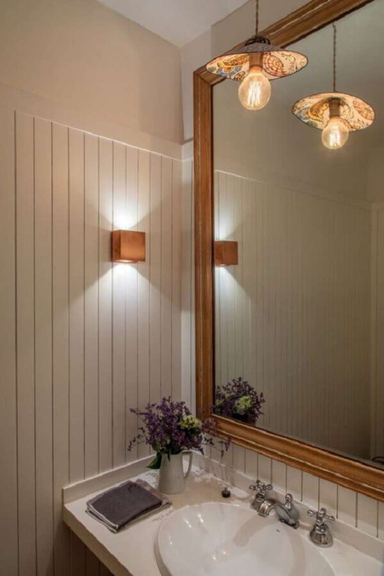 38. Parede de lambri de madeira para decoração de banheiro com espelho grande – Foto: Decor Fácil