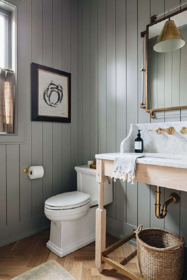 8. Banheiro cinza simples decorado com parede de lambri de madeira – Foto: Better Homes and Gardens