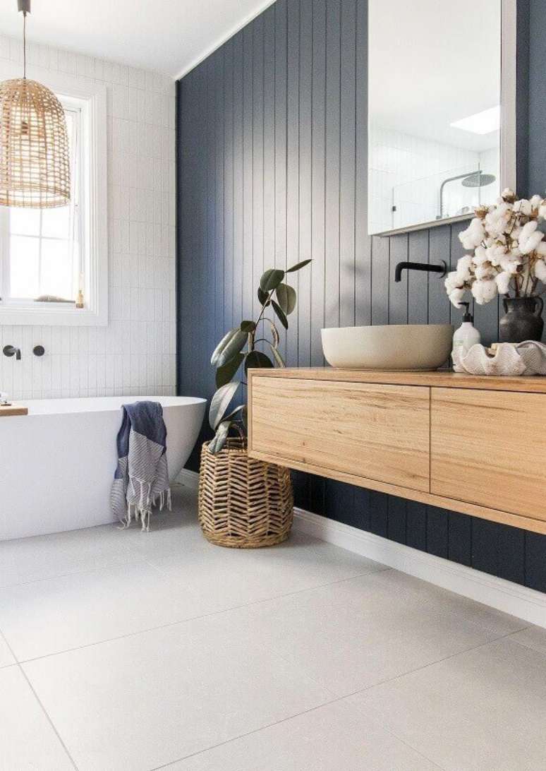 7. Banheiro cinza e branco decorado com banheira de imersão e parede de lambri de madeira – Foto: Style Curator