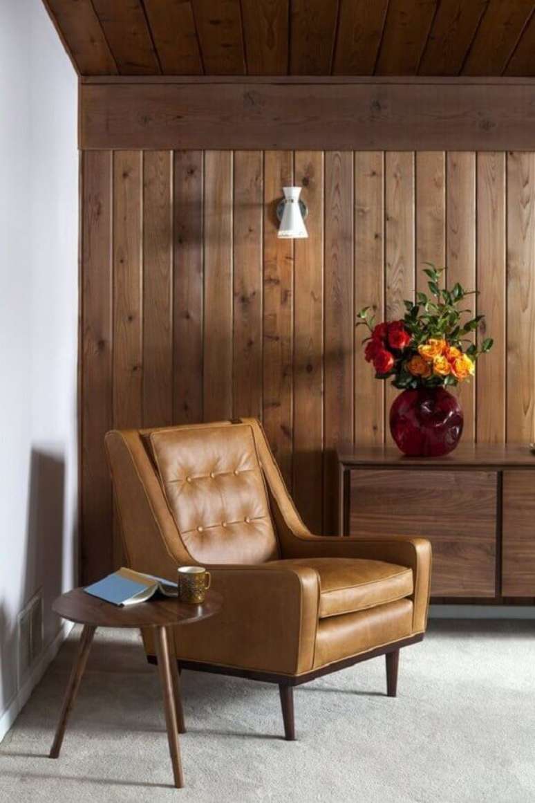 57. Sala rustica decorada com poltrona de couro e lambri de madeira parede – Foto: Dwell