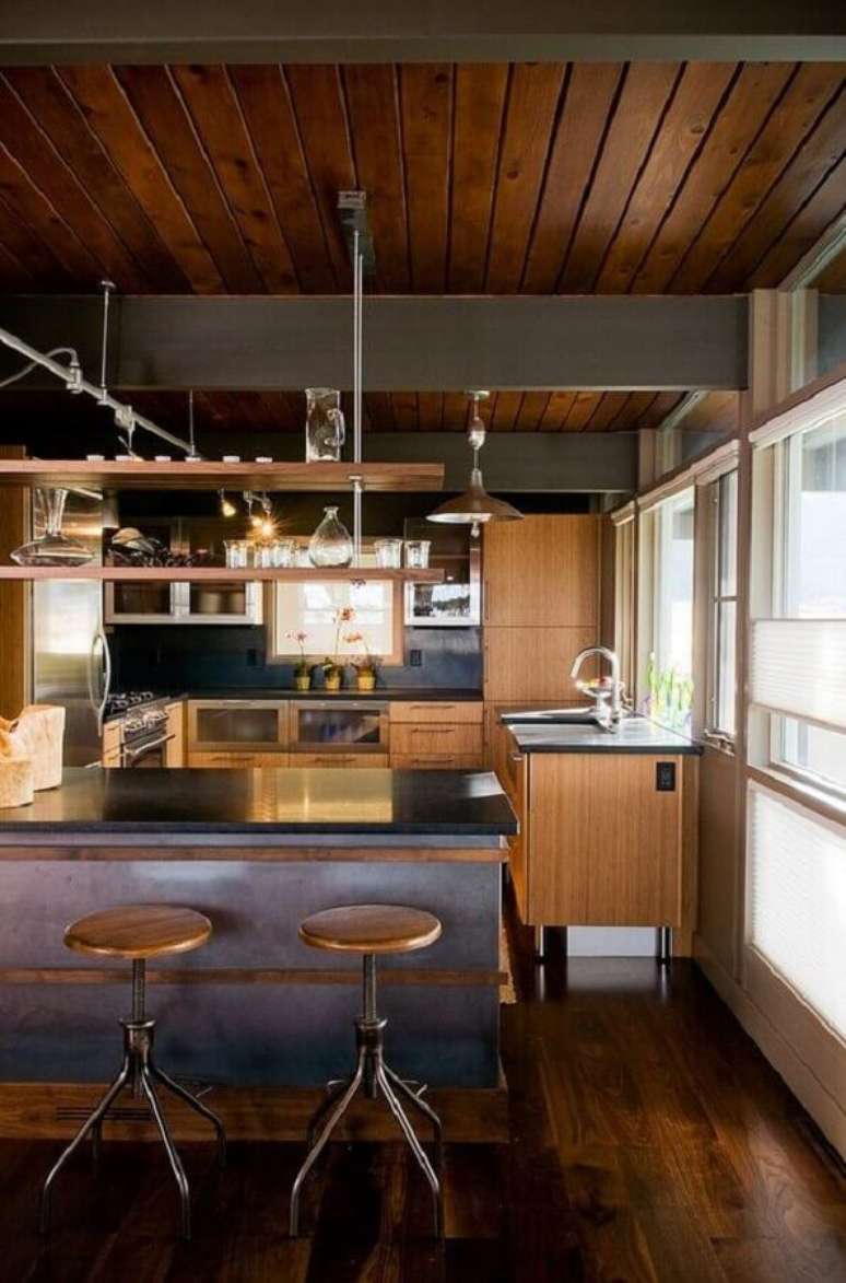 12. Cozinha estilo industrial decorada com teto de lambri de madeira – Foto: HomeAdore