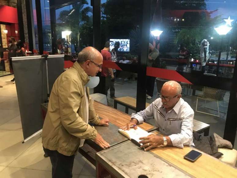 Júnior autografa o livro do  ex-presidente do Flamengo Eduardo Bandeira de Mello (Foto: Matheus Dantas/LANCE!)