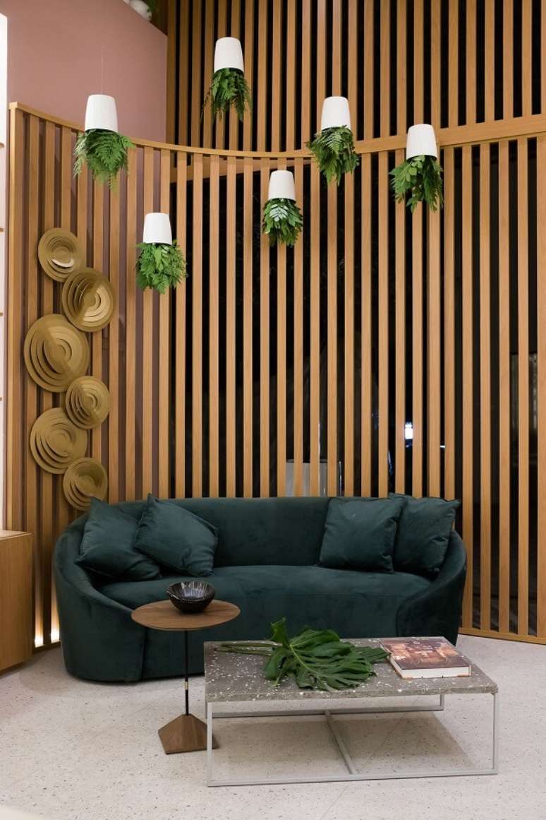 20. Divisória de madeira curvo para sofá verde e plantas na decoração – Foto Casa Cor SP 2021