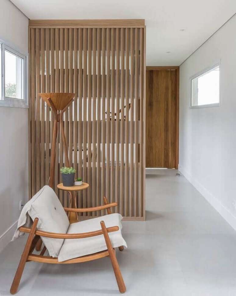 26. Divisória de madeira para sala com poltrona bege e luminária moderna – Foto DZ Studio Arquitetos