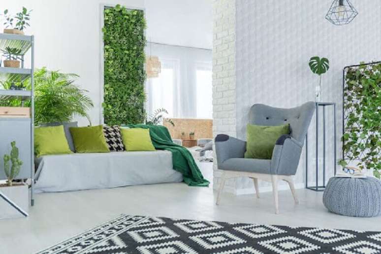 8. Decoração de sala branca e cinza com almofadas verdes e jardim vertical – Foto: habitíssimo