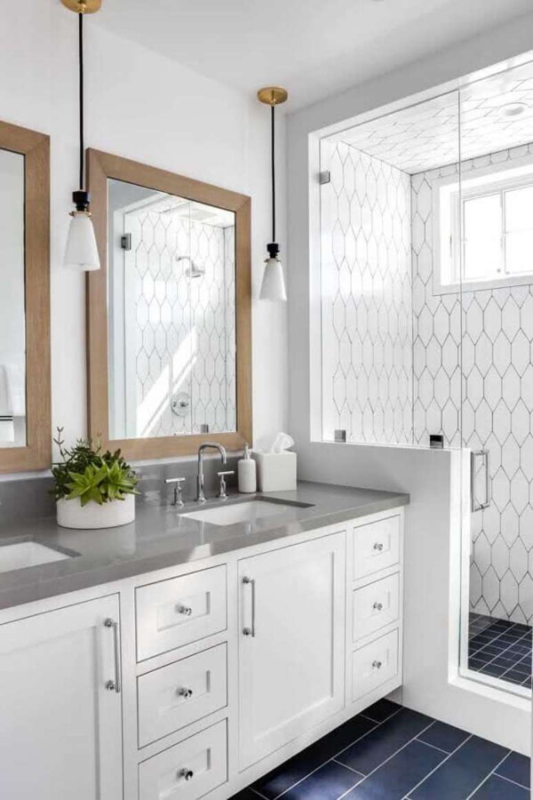 6. Azulejo branco colmeia para decoração de banheiro com piso preto e espelho de madeira – Foto: Houzz