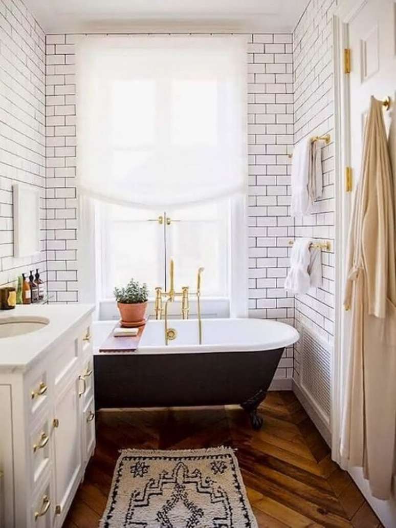 7. Torneira dourada e suporte de banheira simples em madeira decoram o c&ocirc;modo. Fonte: Casa e Festa