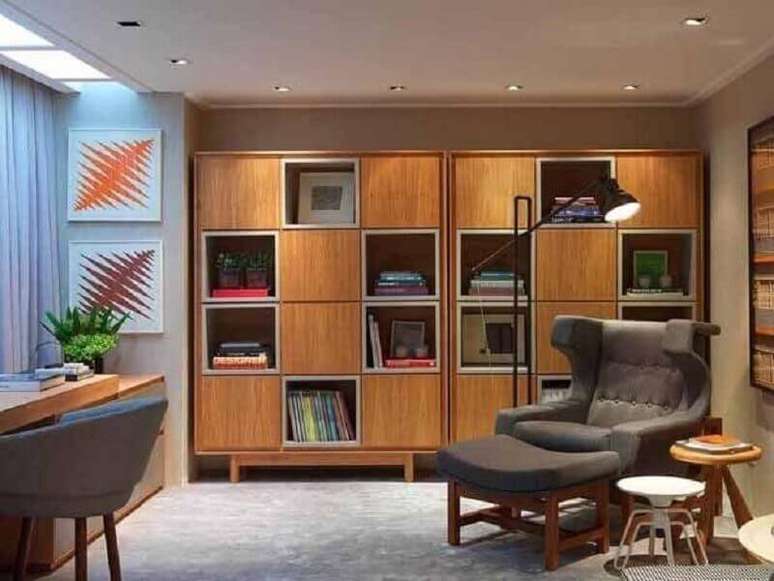 44. Escritório moderno decorado com poltrona cinza confortável e armário para colocar livros – Foto: Sergio Rodrigues
