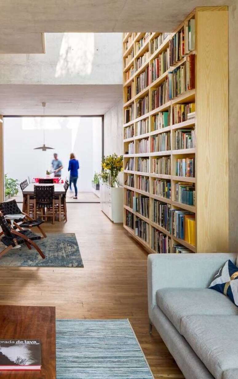 22. Casa conceito aberto decorada com armário para livros de madeira planejado com nichos – Foto: Houzz