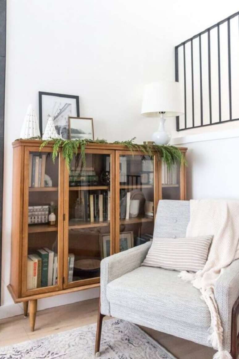14. Armário para livros fechado para cantinho de leitura decorado com poltrona confortável – Foto: Kristina Lynne