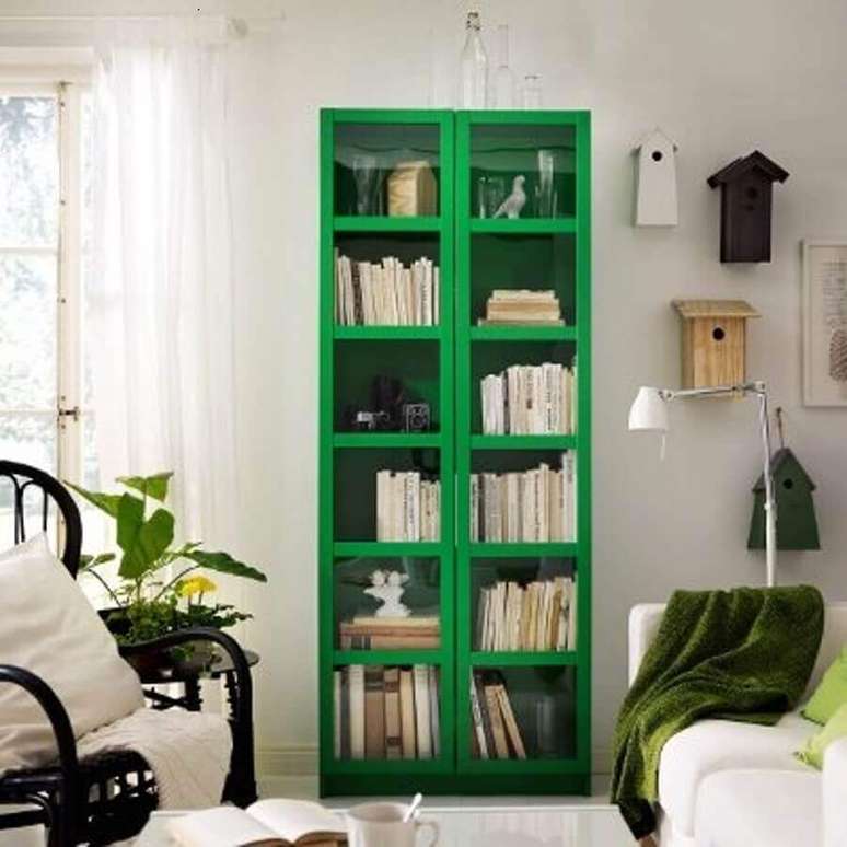 56. Sala simples decorada com armário para livros com porta de vidro verde – Foto: Apartment Therapy