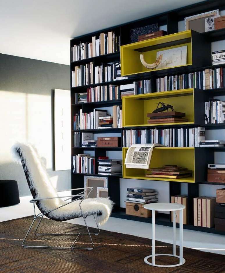 2. Decoração de cantinho de leitura com poltrona moderna e armário para guardar livros – Foto: Yandex
