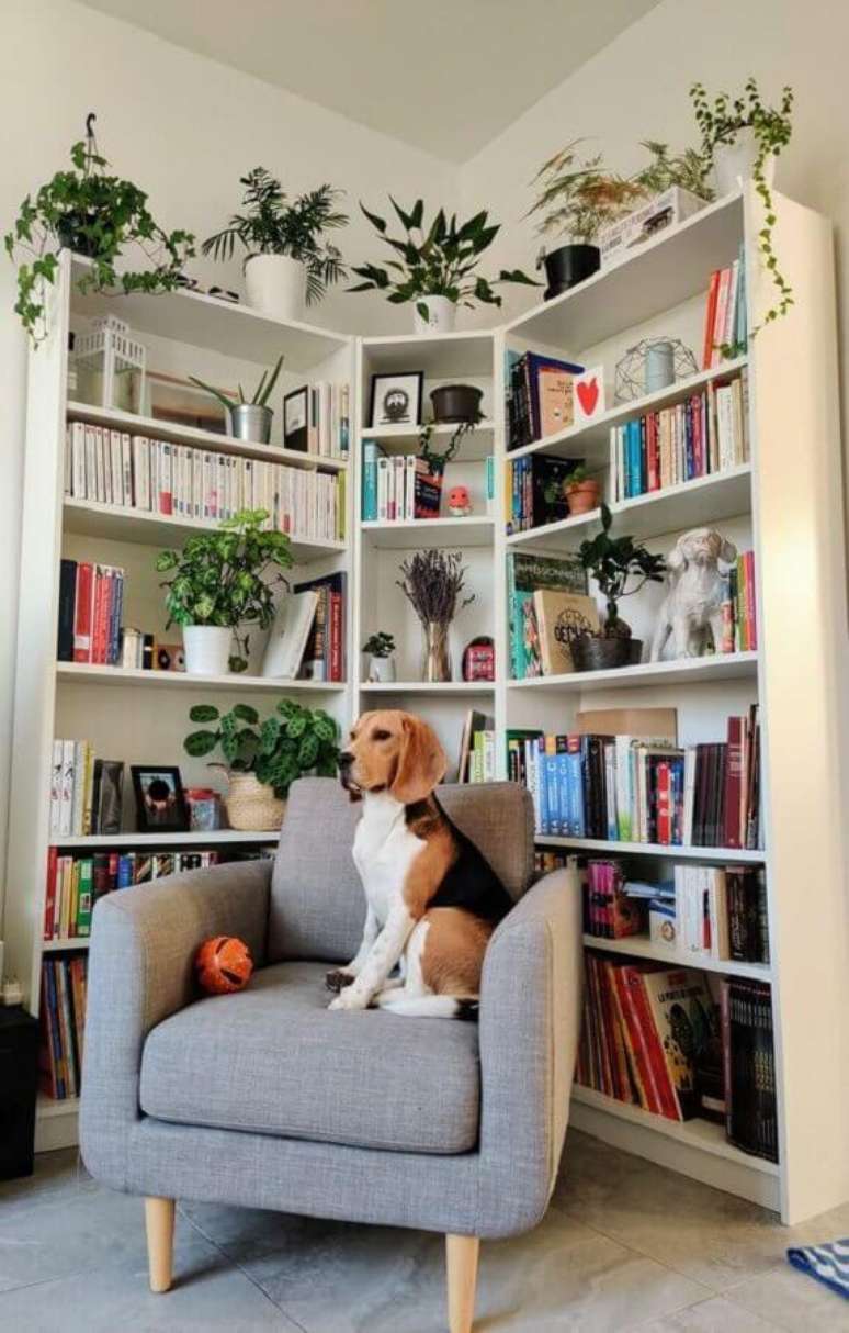 1. Armário para livros de canto para decoração de cantinho de leitura com poltrona cinza confortável – Foto: EV Gezmesi