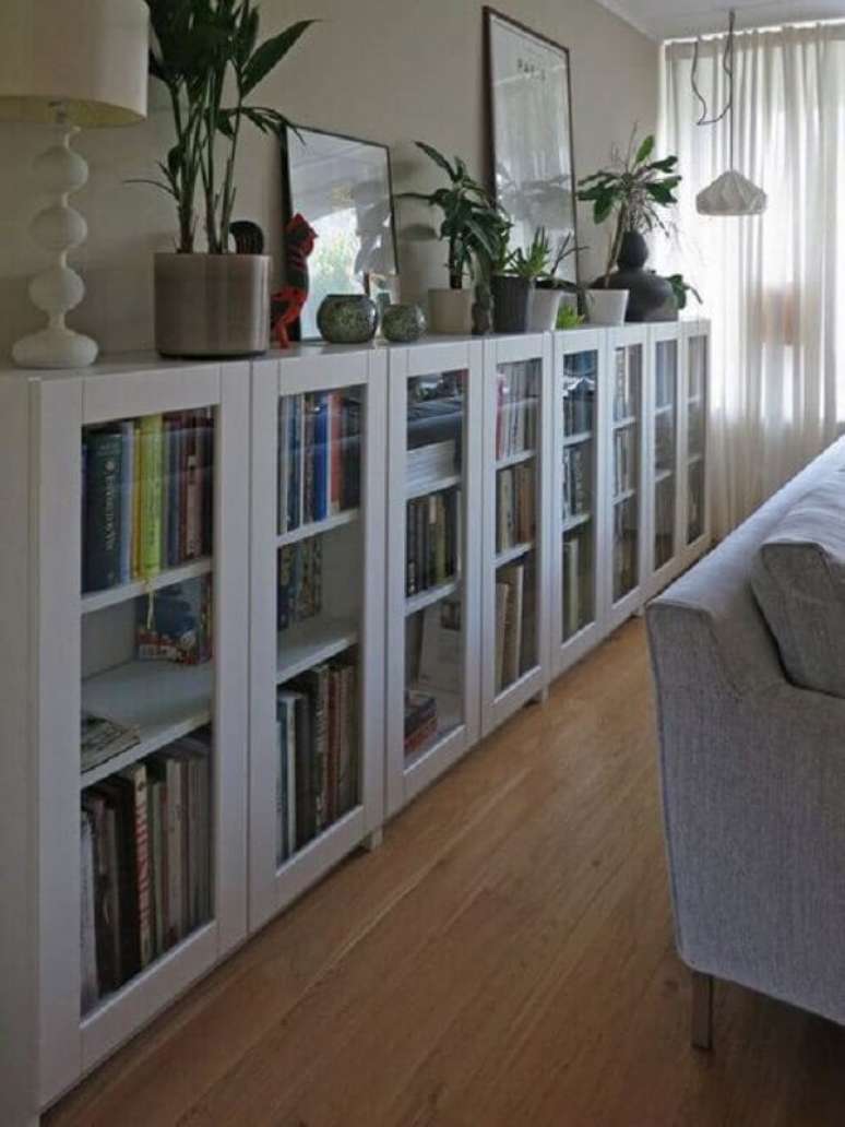 52. Sala decorada com vasos de plantas sobre armário para livros fechado com porta de vidro – Foto: Idea Stand