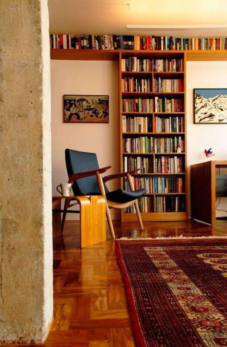11. Armário para colocar livros para decoração de sala com poltrona de madeira – Foto: ODVO Arquitetura e Urbanismo